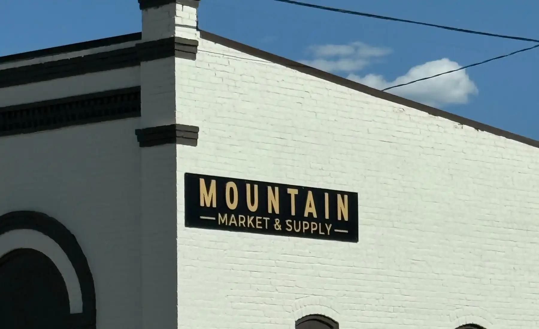 The Mountain Market & Supply sign on the white brick building in downtown Eagle